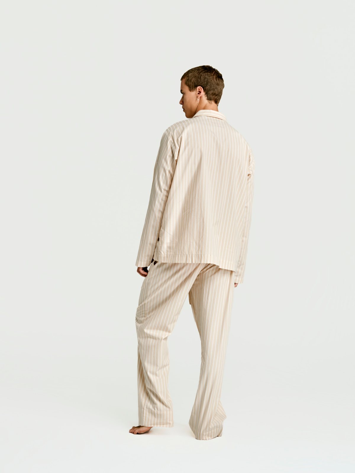 Man in the sand stripe long set seen from behind